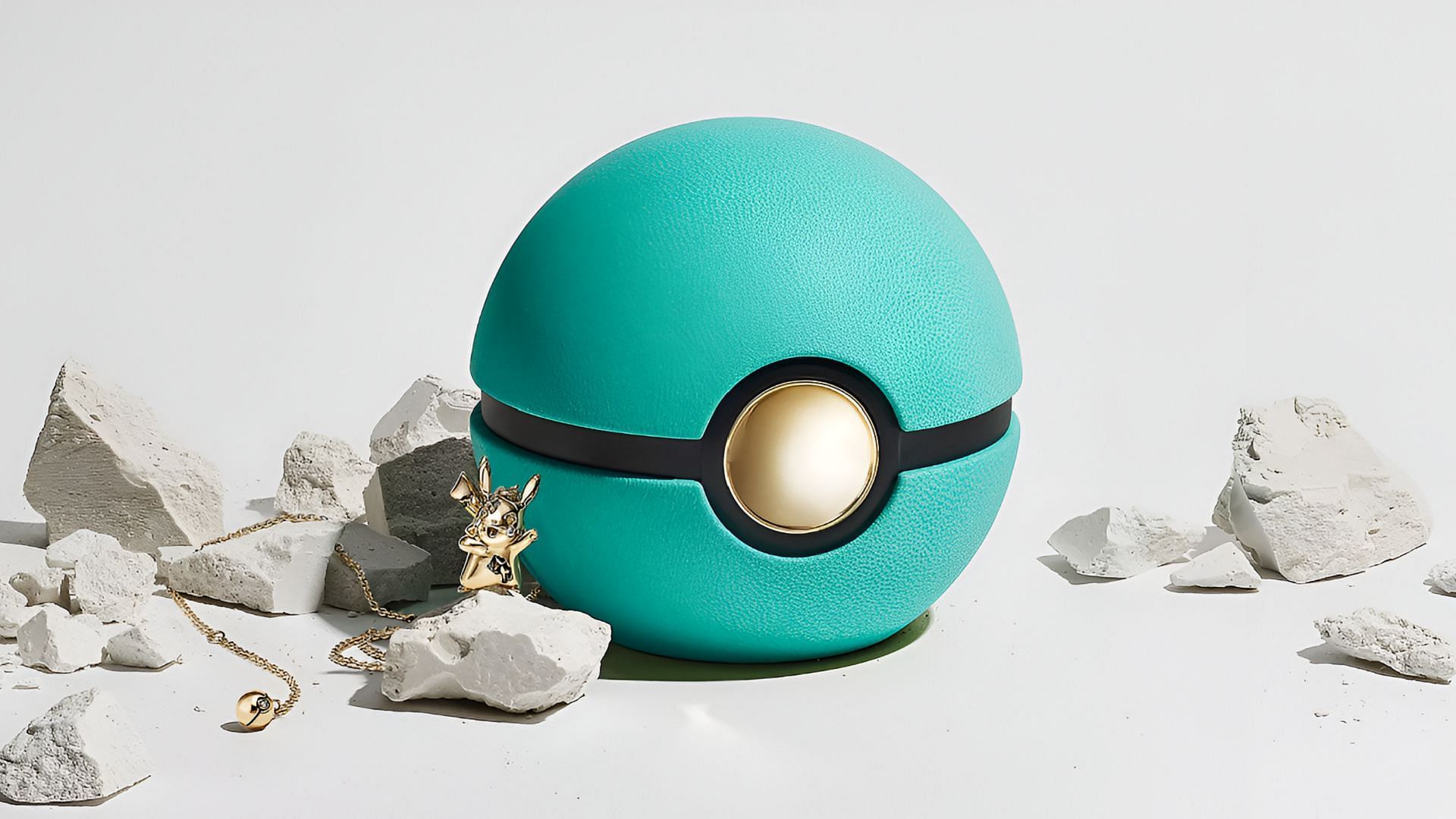 A teal and gold Poke Ball featuring Pokemon jewelry resembling Pikachu.