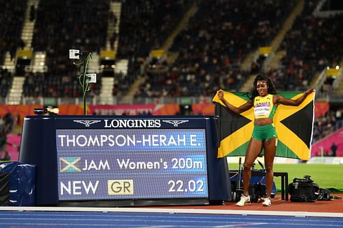 Elaine Thompson-Herah of Team Jamaica celebrates a new Games Record next to the time board after winning the gold medal in the Women's 200m Final at the 2022 Commonwealth Games in Birmingham, England.