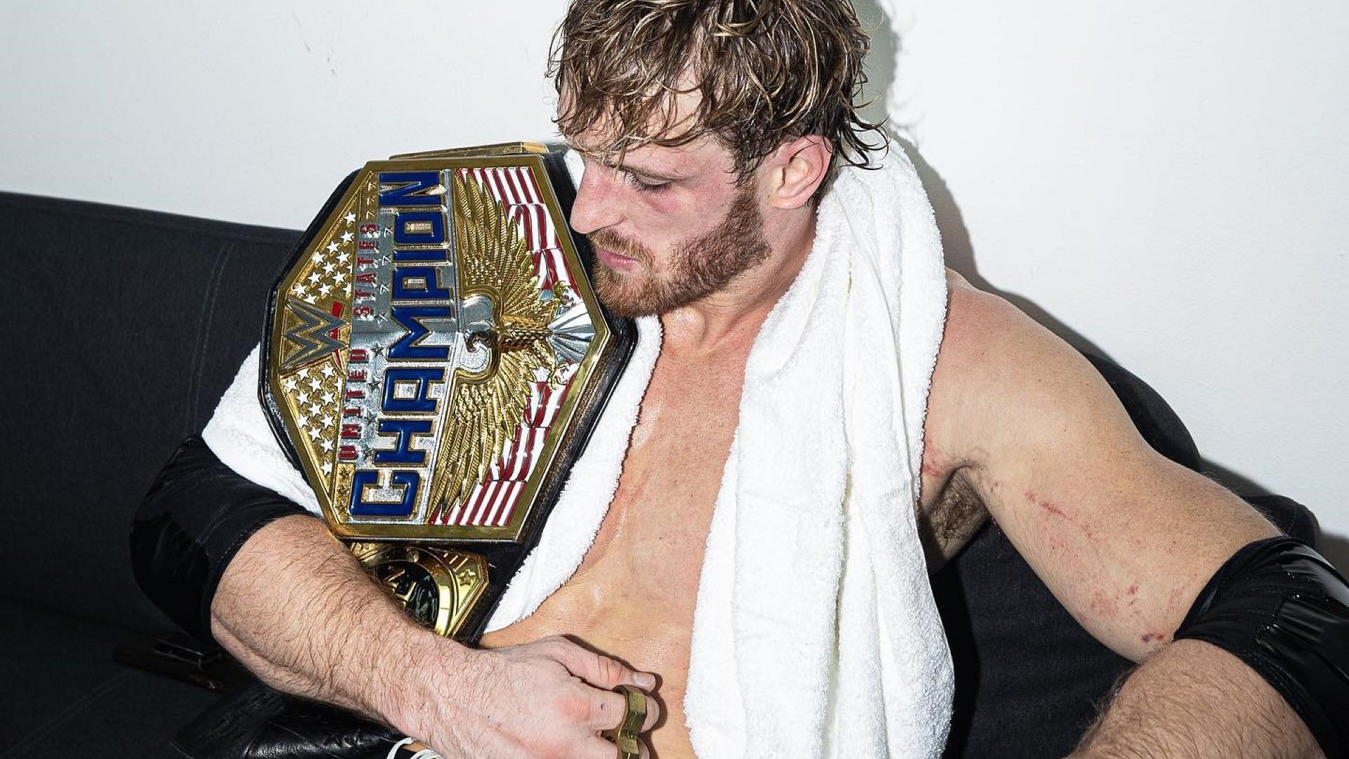 Logan Paul sits with the WWE United States Championship