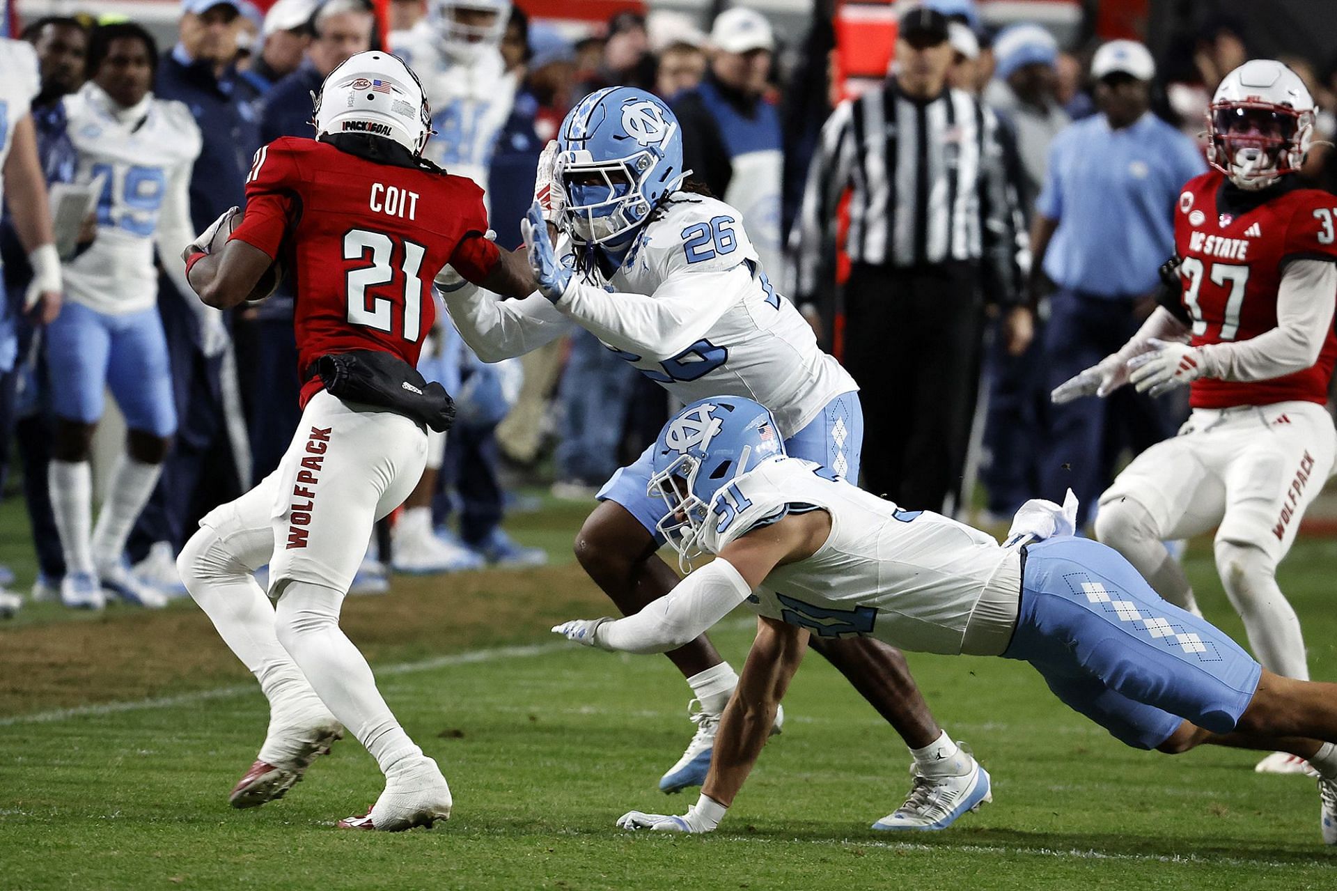 North Carolina State&#039;s Jalen Coit is tackled by North Carolina&#039;s D.J. Jones (26) and Will Hardy in Raleigh, N.C., on Nov. 25. (AP Photo/Karl B DeBlaker)