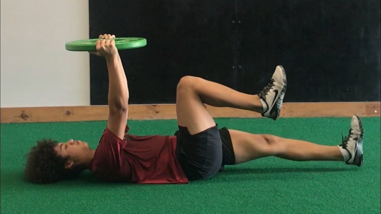 Weighted dead bug exercise (Image via YouTube/Alex Simone)