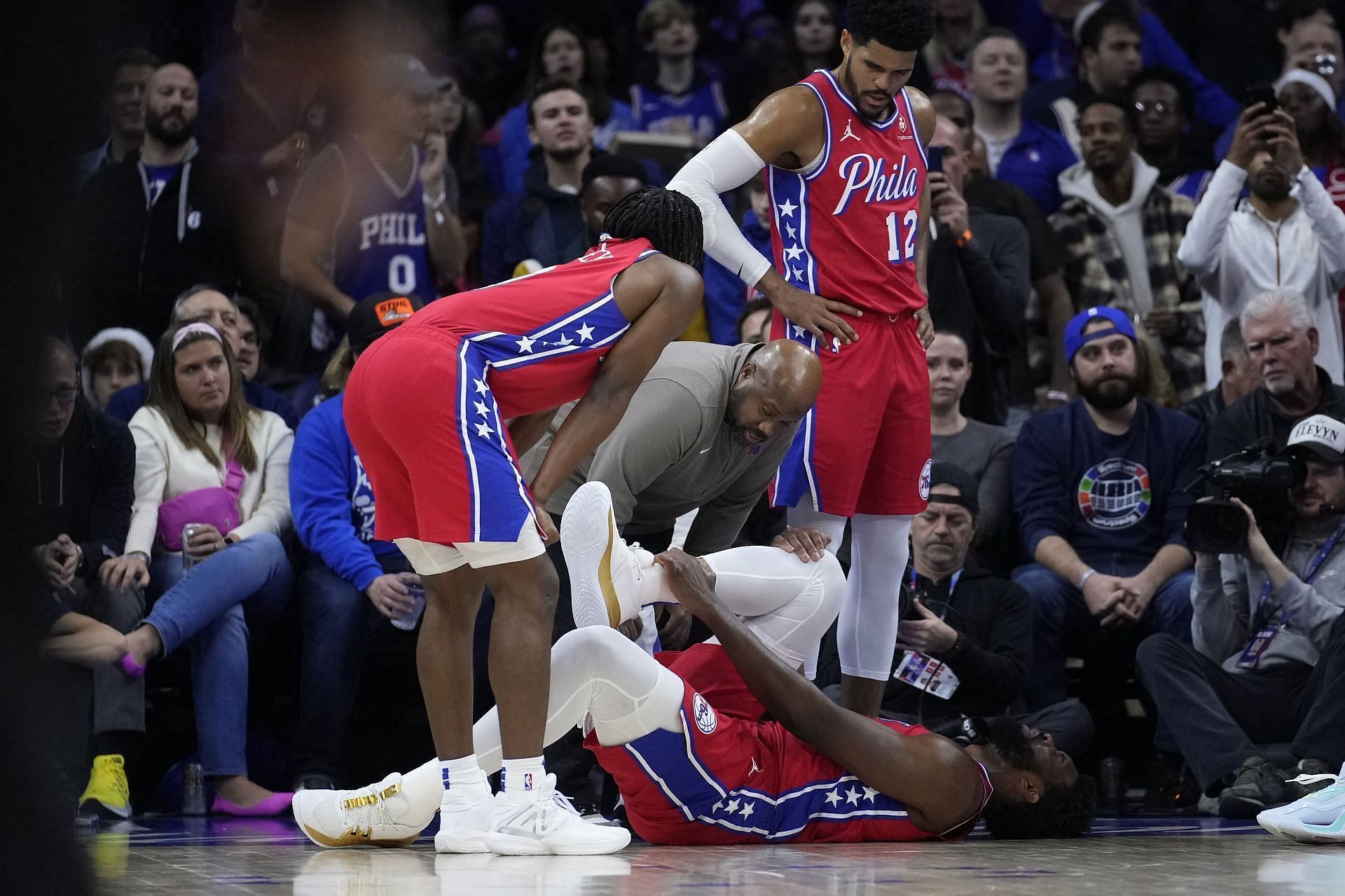 Joel Embiid screams as he falls to the ground.