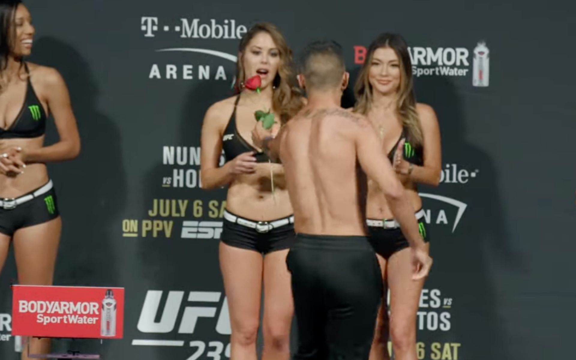 Nohelin Hernandez (front) giving Brittney Palmer (back) a rose at the UFC 239 weigh in [Photo Courtesy of MMAFightingonSBN on YouTube]