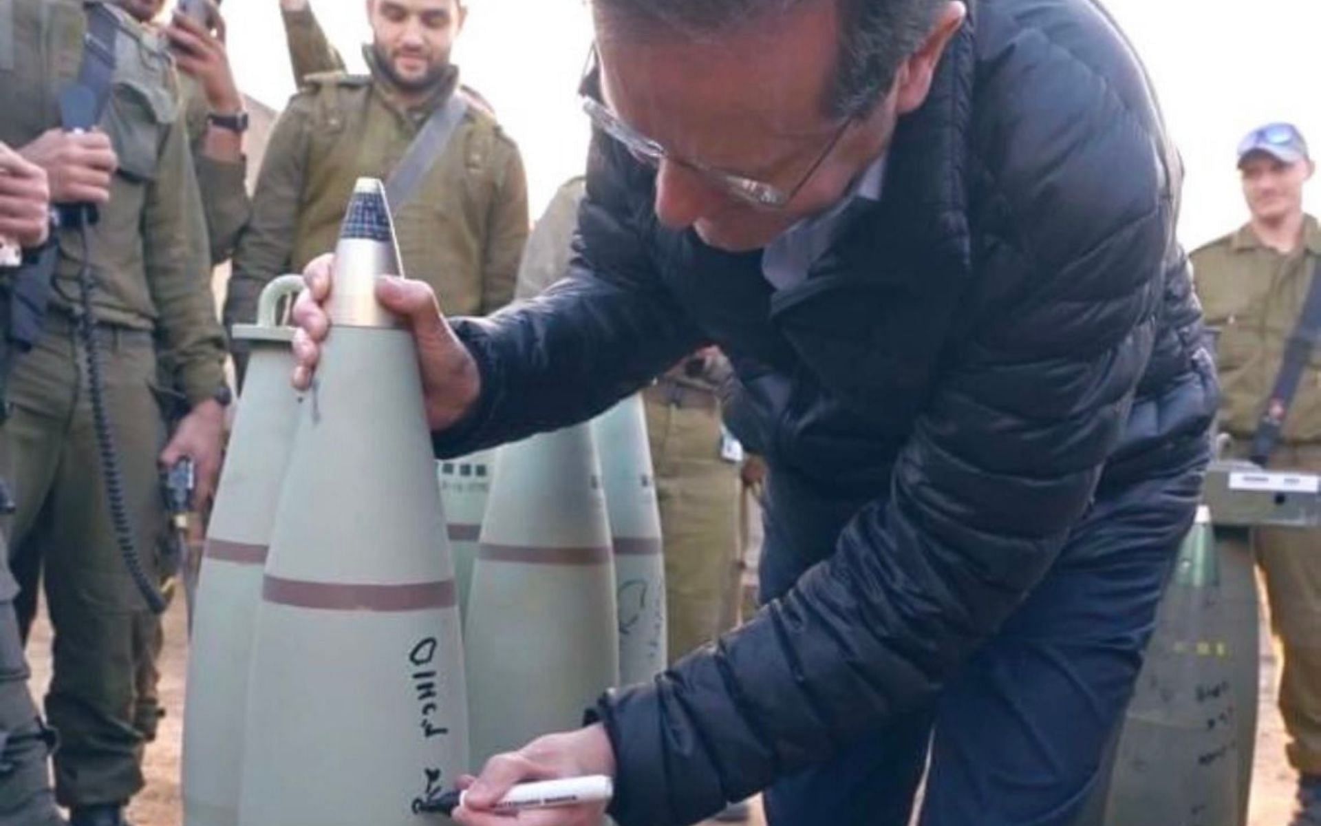 Israeli President Isaac Herzog writing messages on missiles (Image Courtesy - @jakeshieldsajj on X/Twitter)