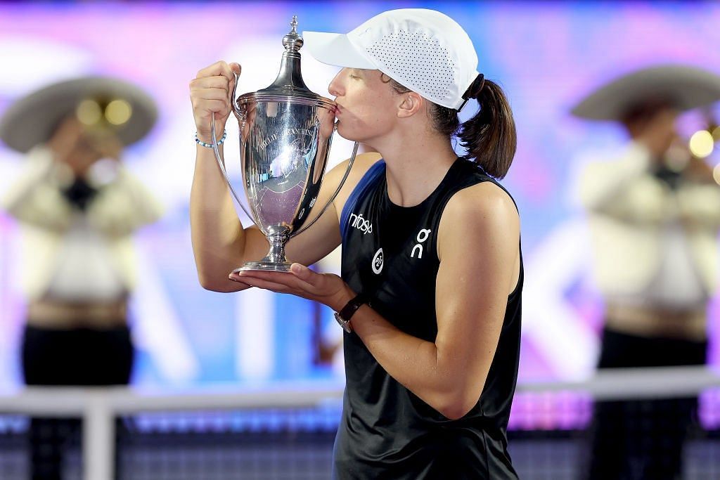 Iga Swiatek poses with the 2023 WTA Finals trophy