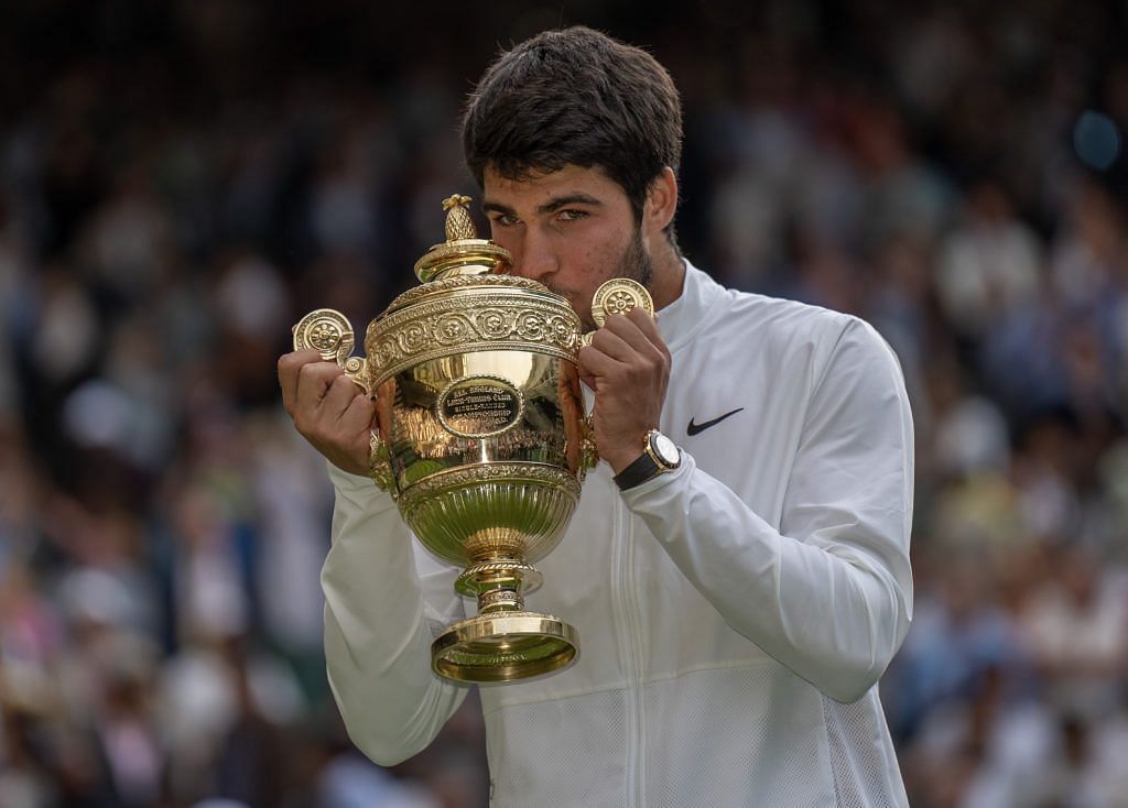 Carlos Alcaraz poses with the Wimbledon trophy