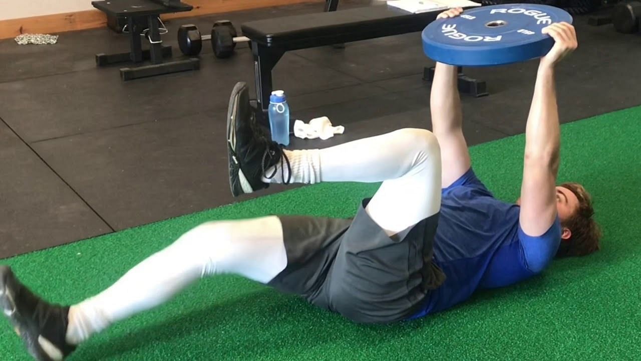 Weighted dead bug exercise (Image via YouTube/Alex Simone)