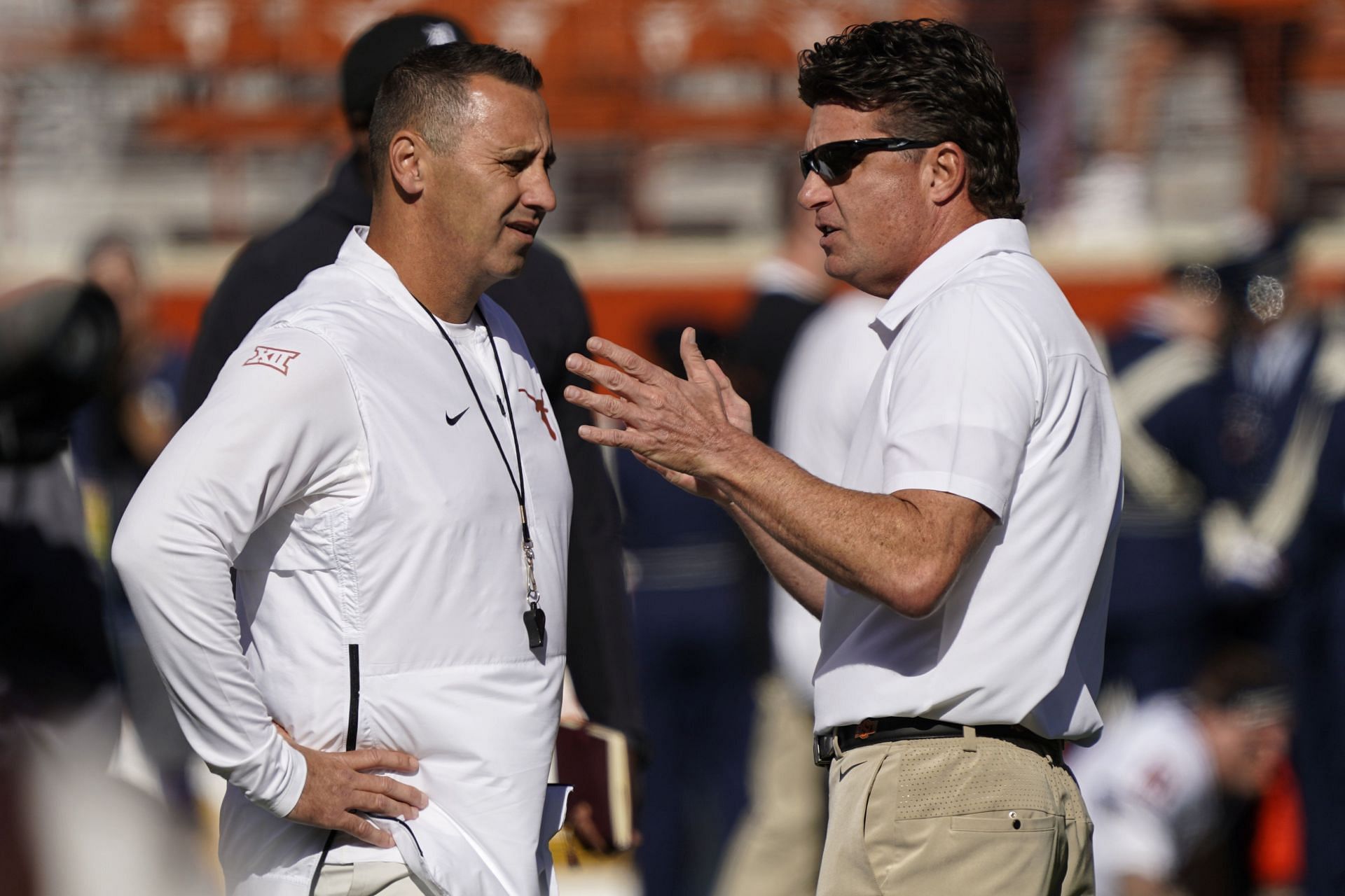 Texas head coach Steve Sarkisian, left, talks with Oklahoma State head coach Mike Gundy. (AP Photo/Chuck Burton, File)