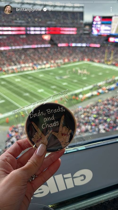 Brittany Mahomes holds a cookie with a message about the NFL's media coverage of Taylor Swift