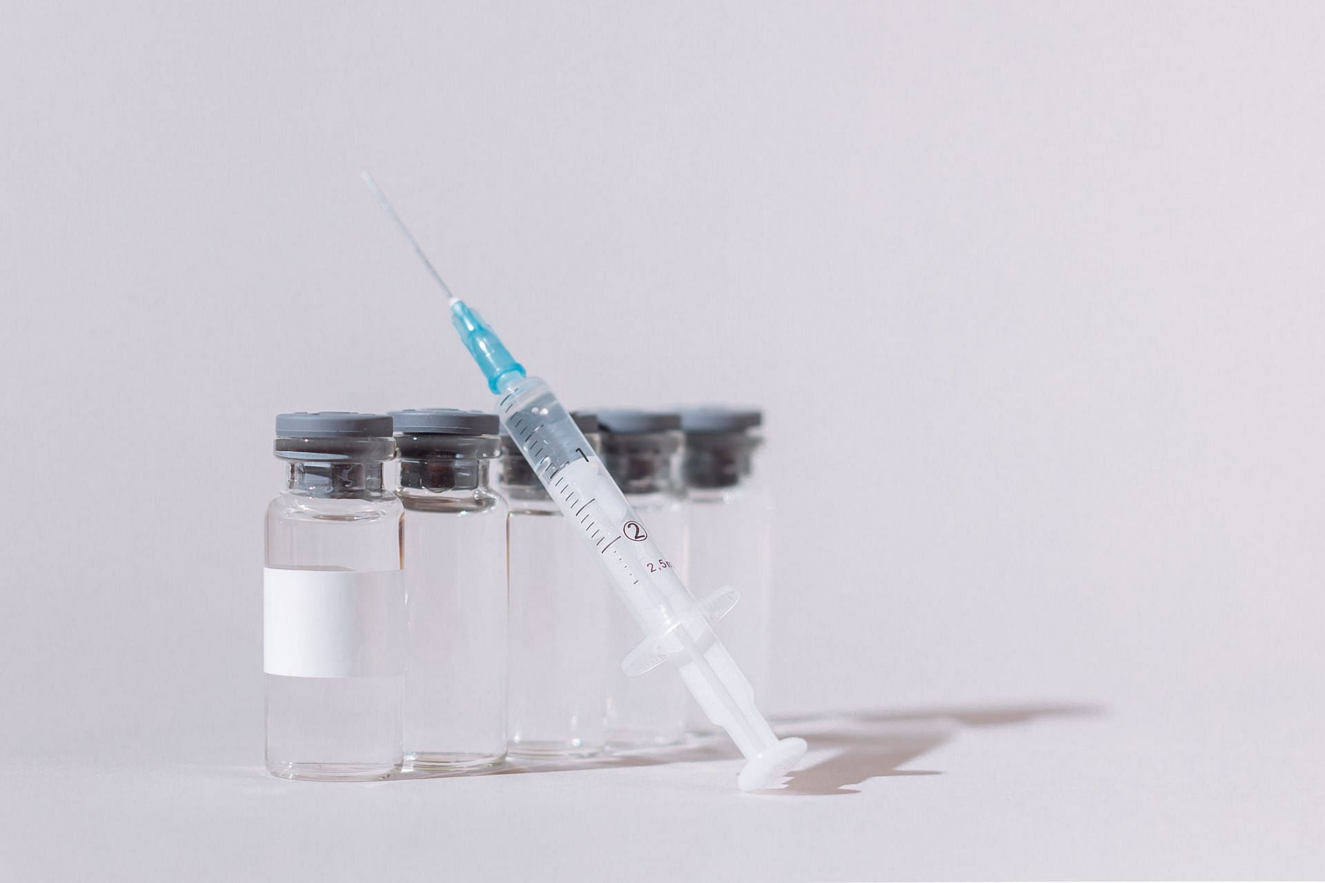 Syringes representative image with vaccine bottles