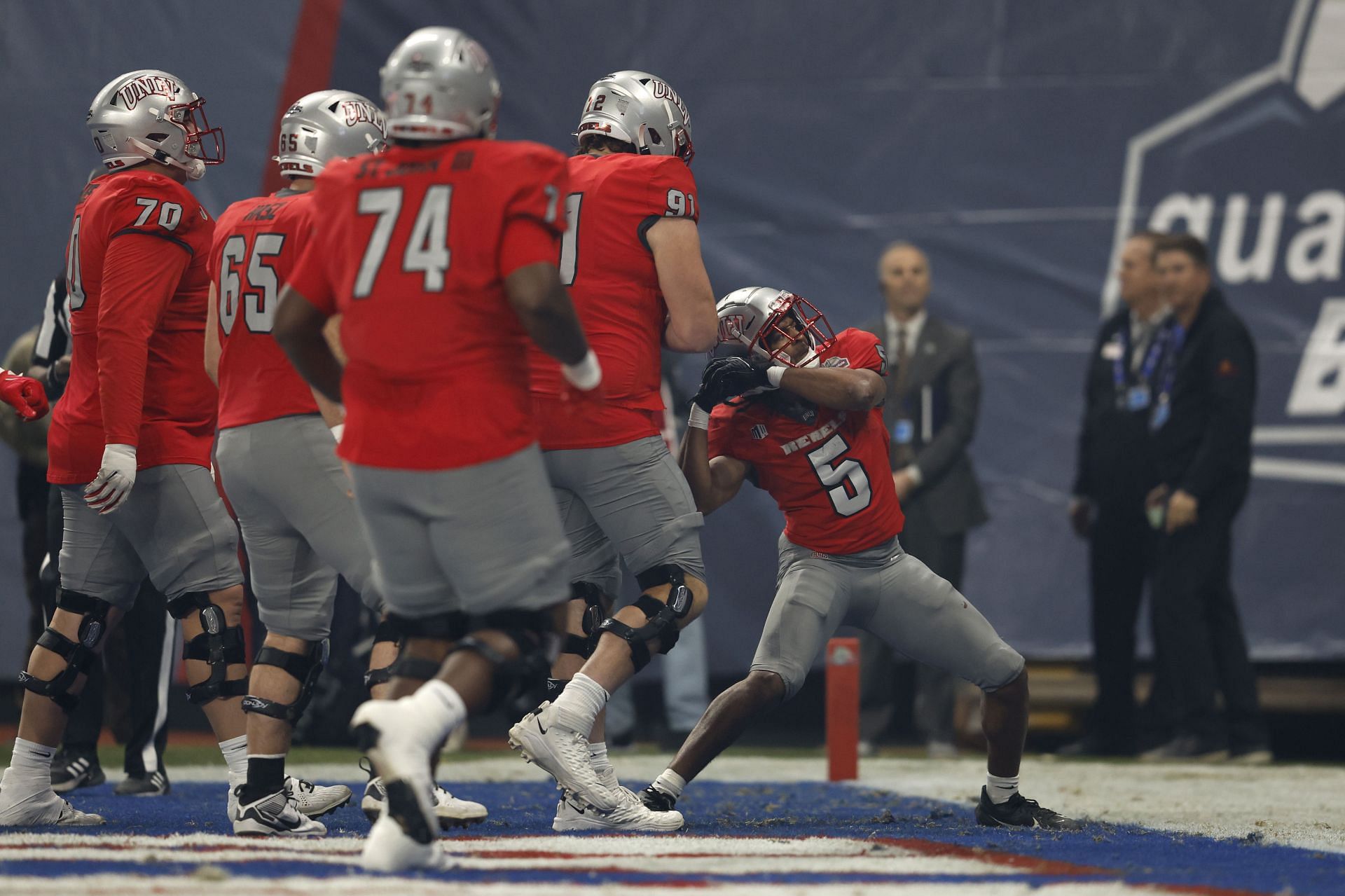 Running back Vincent Davis Jr. #5 of the UNLV Rebels celebrates a touchdown during the first half of the Guaranteed Rate Bowl against the Kansas Jayhawks at Chase Field on December 26, 2023