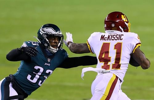 Running back J.D. McKissic #41 of the Washington Football Team is tackled by back Elijah of the Philadelphia Eagles after completing a pass