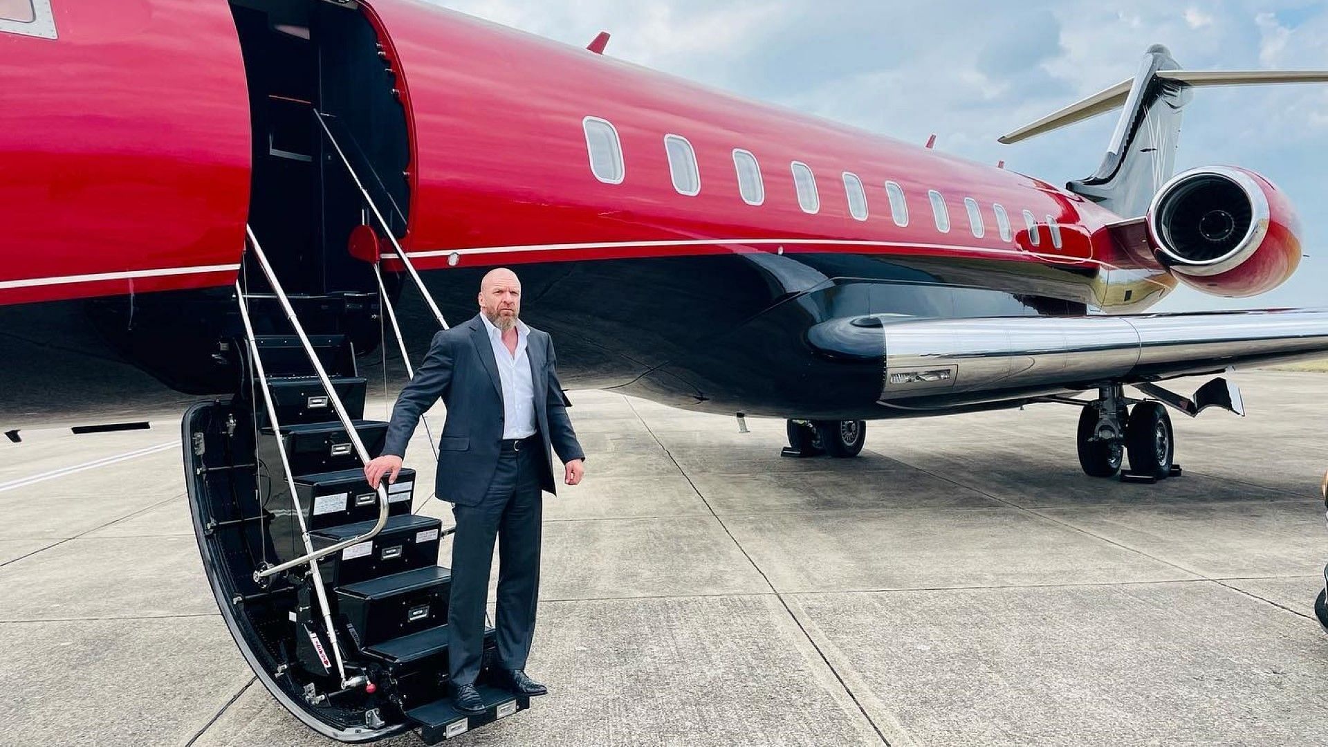 WWE Chief Content Officer Triple H steps off the company jet onto an airport runway