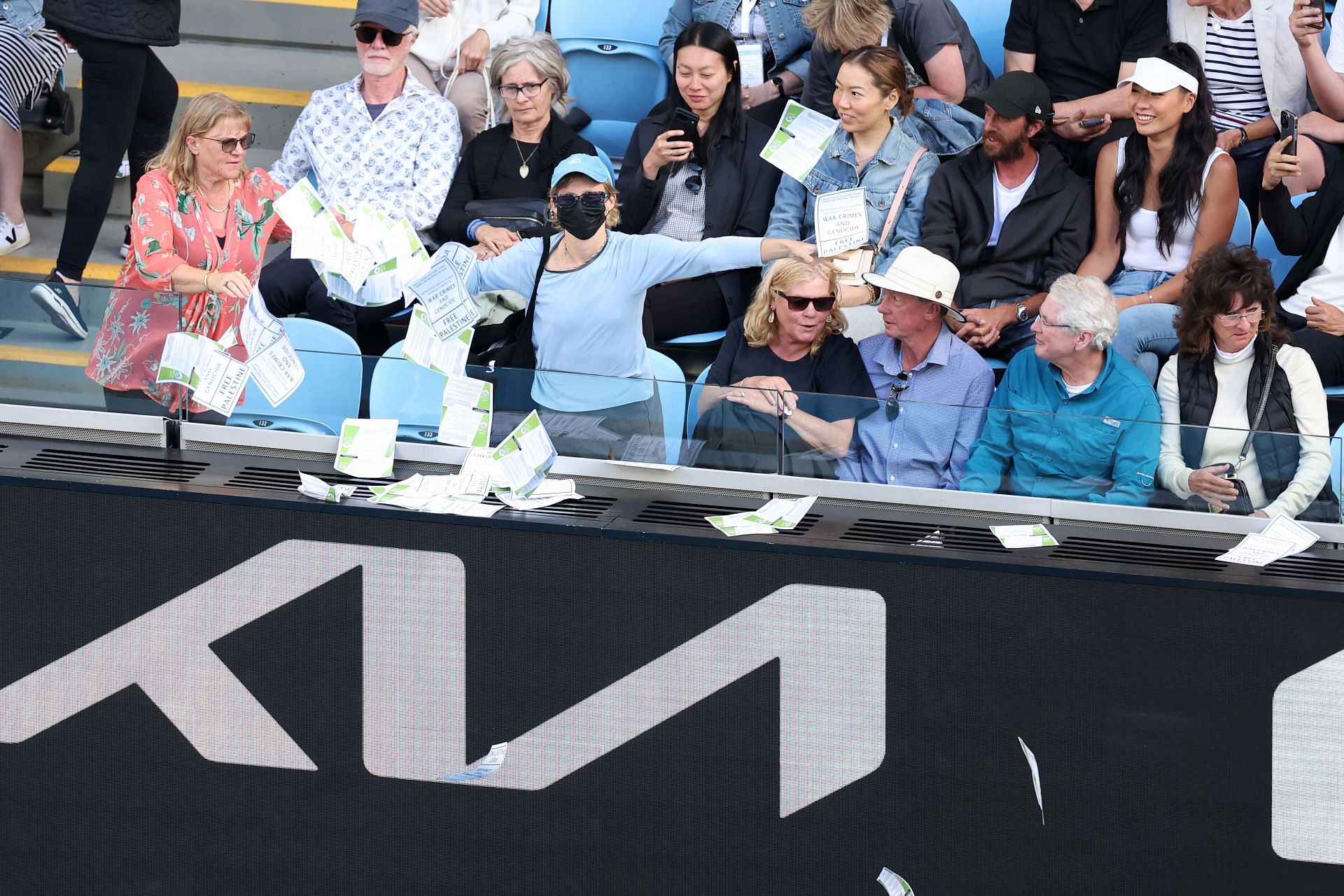 Protestors throw pamphlets on the court during a match between Alexander Zverev and Cameron Norrie