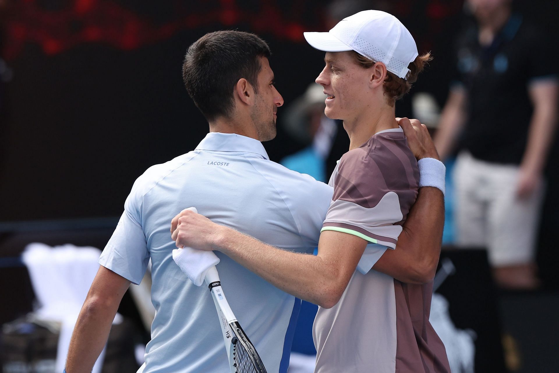 Novak Djokovic and Jannik Sinner embrace at the 2024 Australian Open