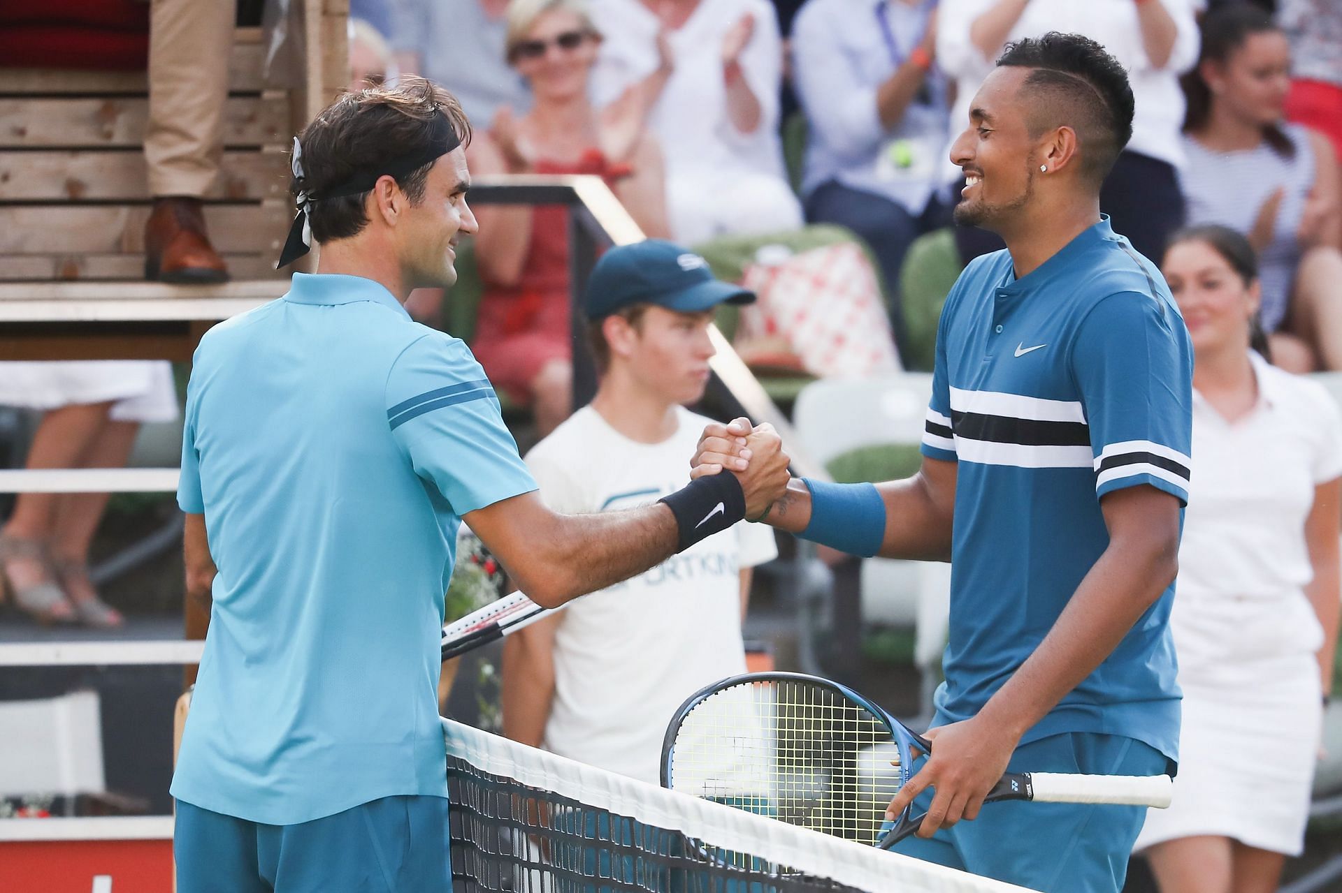 Roger Federer and Nick Kyrgios shake hands.