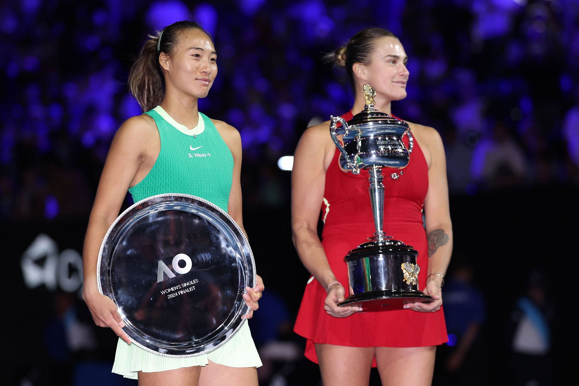 Zheng Qinwen (L) and Aryna Sabalenka at the 2024 Australian Open trophy ceremony