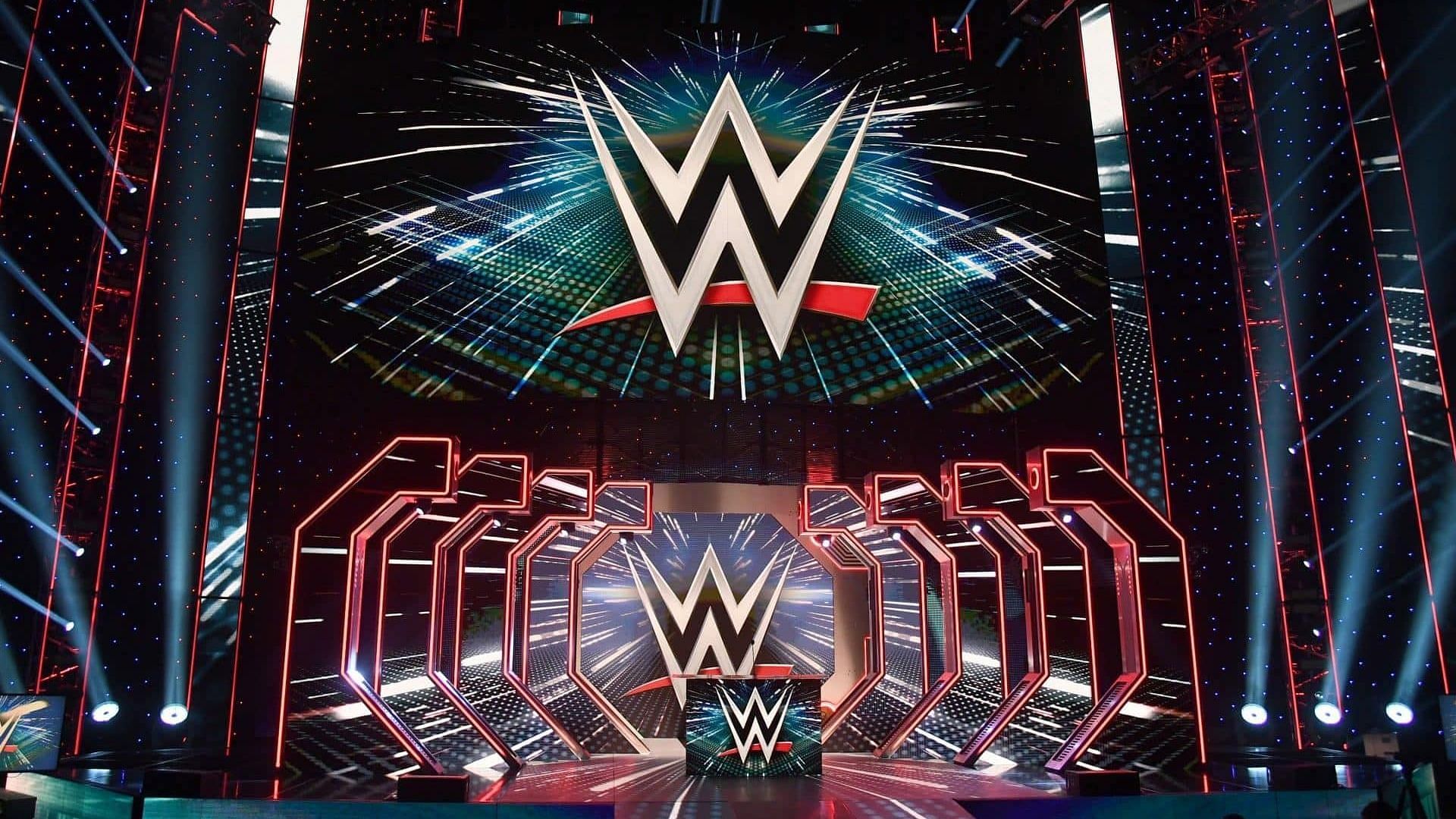 The WWE logos on display with the stage/set inside an arena