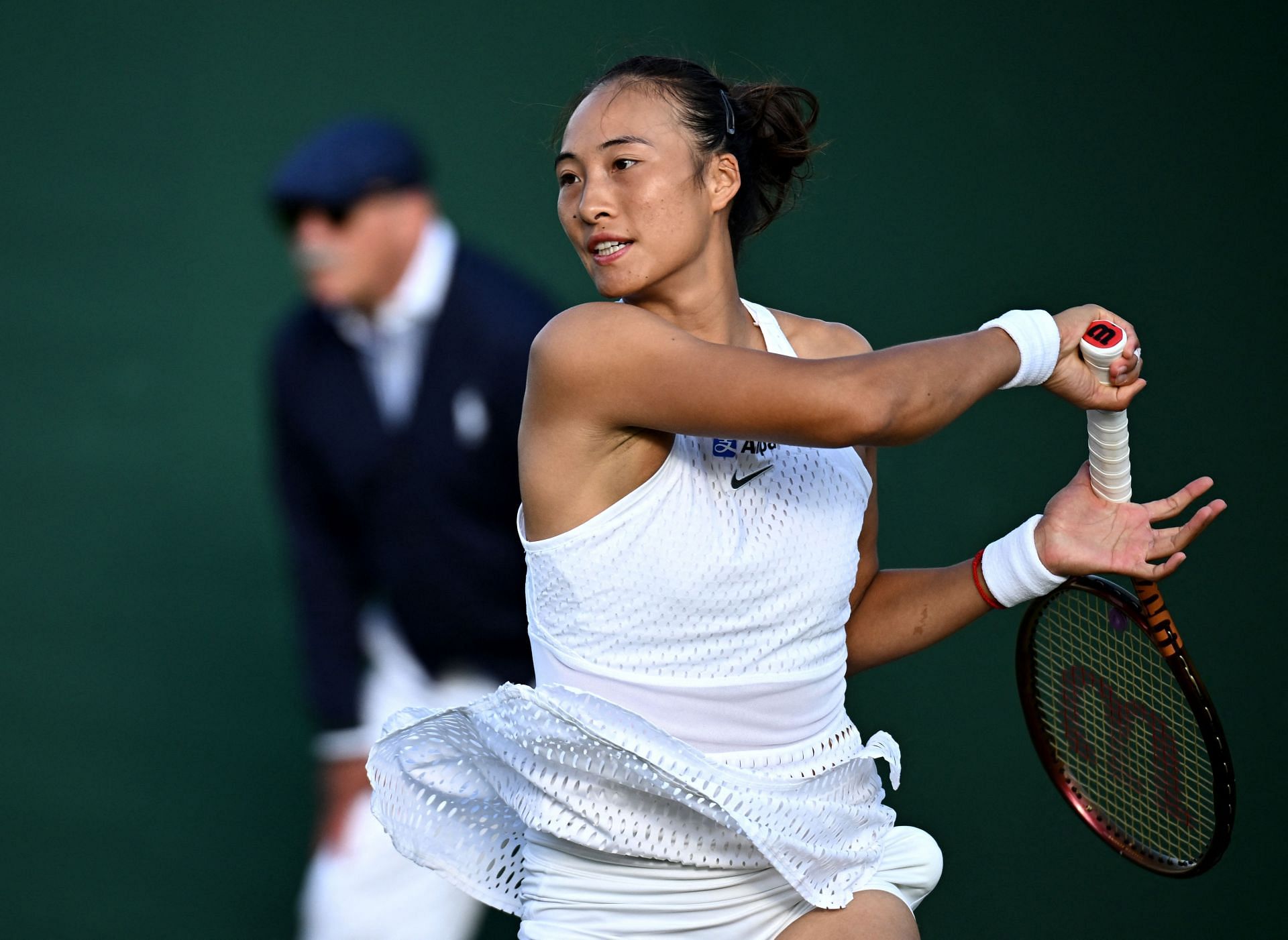 Zheng Qinwen hits a forehand at Wimbledon.