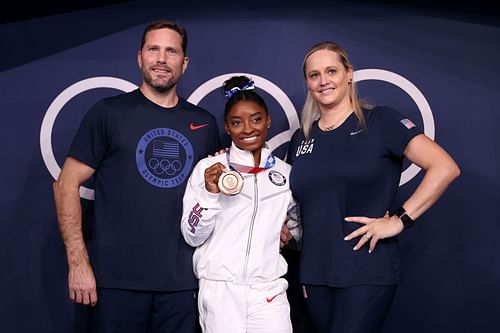 Simone Biles of Team United States poses with the bronze medal alongside coaches Laurent Landi and Cecile Canqueteau-Landi following the Women's Balance Beam Final at the 2020 Olympic Games in Tokyo, Japan Gymnastics.