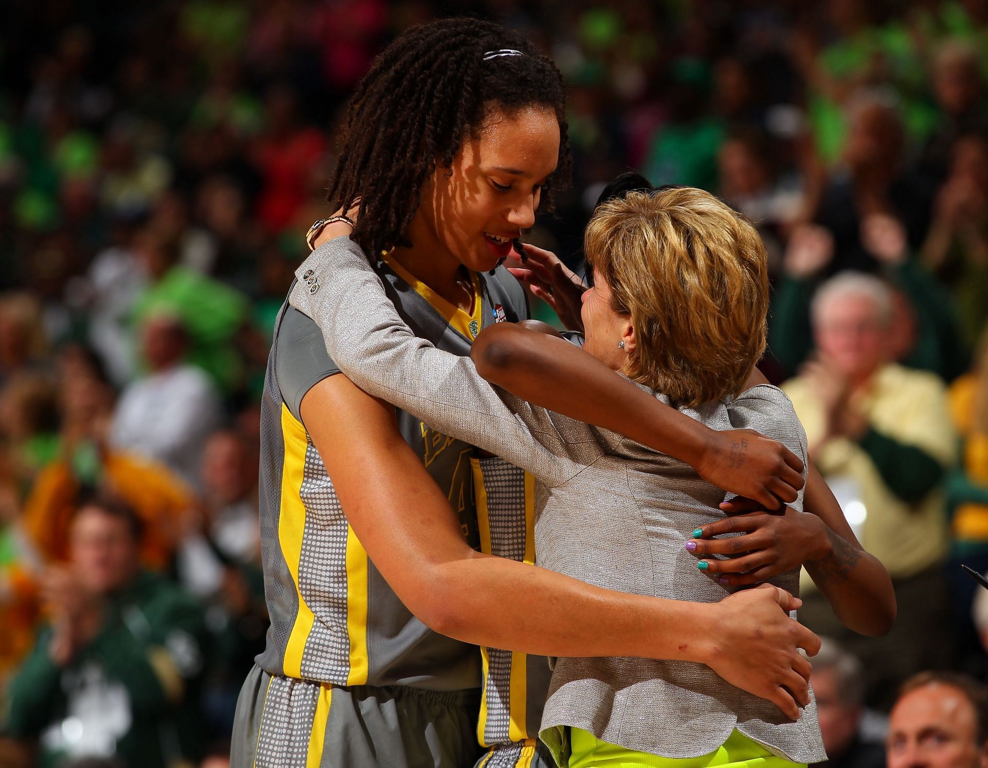 Brittney Griner #42 (L) and Jordan Madden (obscured) #3 of the Baylor Bears hug head coach Kim Mulkey