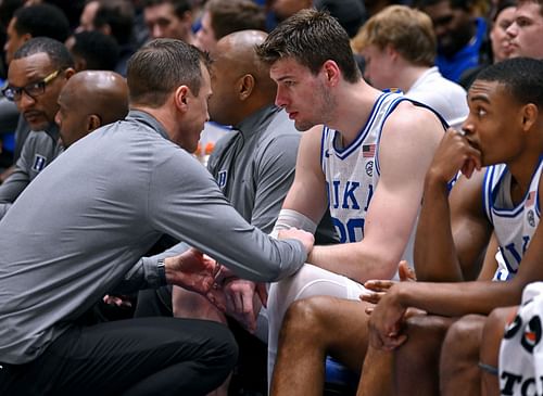 Coach Jon Scheyer talks with Kyle Filipowski of the Duke Blue Devils.