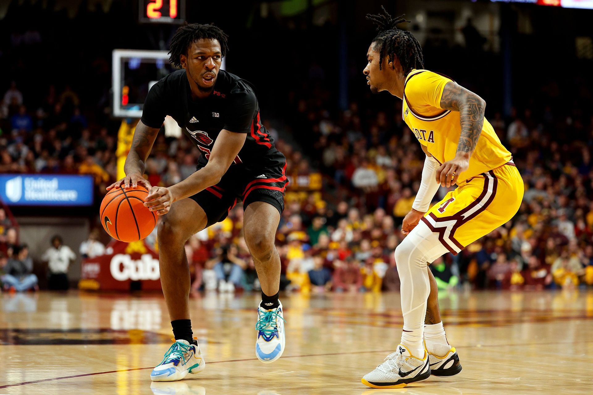 Jeremiah Williams #25 of the Rutgers Scarlet Knights dribbles the ball against Elijah Hawkins #0 of the Minnesota Golden Gophers.