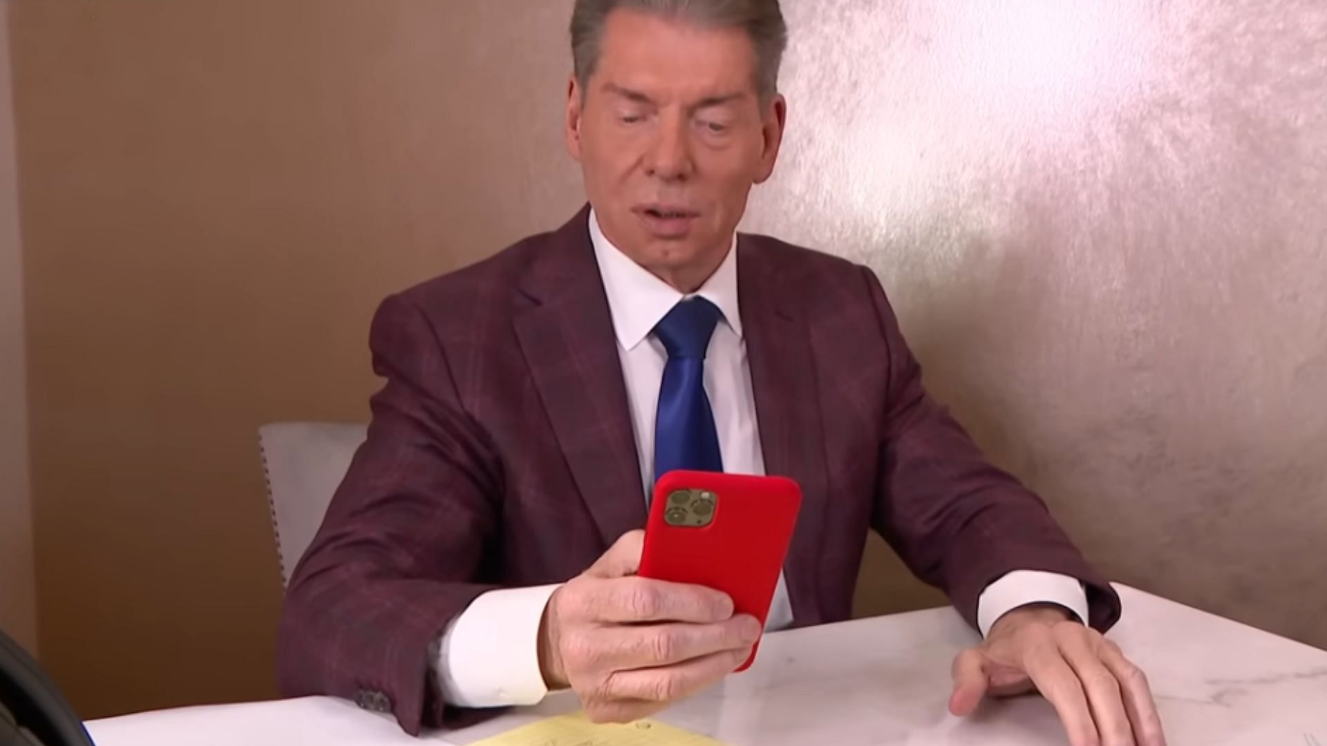 Vince McMahon checking his phone (via WWE