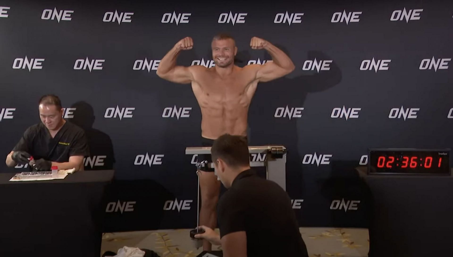 Anatoly Malykhin flexes at the ONE 166 weigh-ins in Doha.