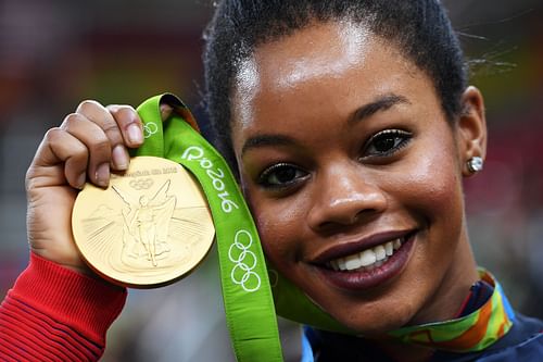 Gabby Douglas of the United States poses for photographs with her gold medal after the medal ceremony for the Artistic Gymnastics Women's Team at the 2016 Olympic Games in Rio de Janeiro, Brazil.