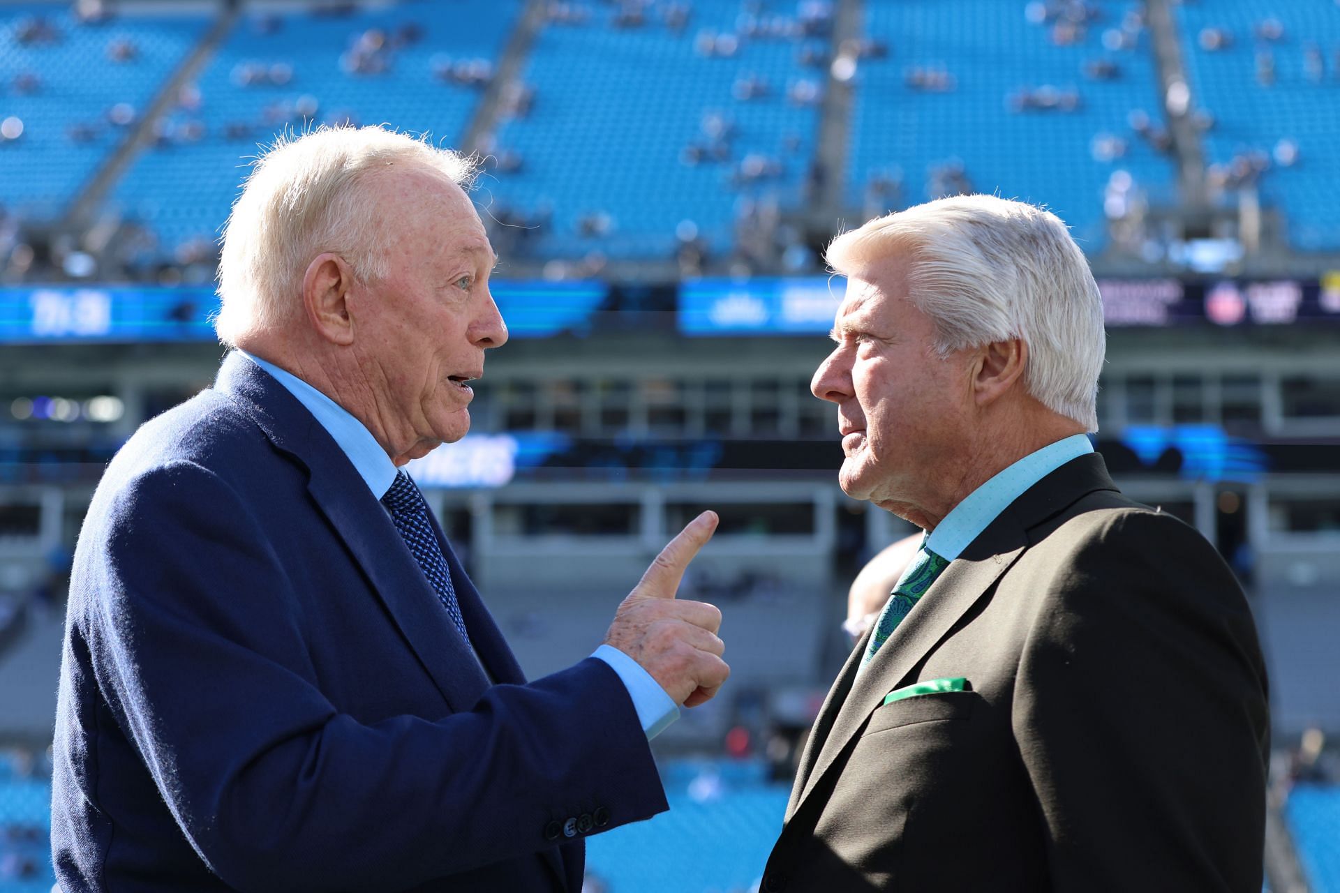 Jerry Jones and Jimmy Johnson talking at a game