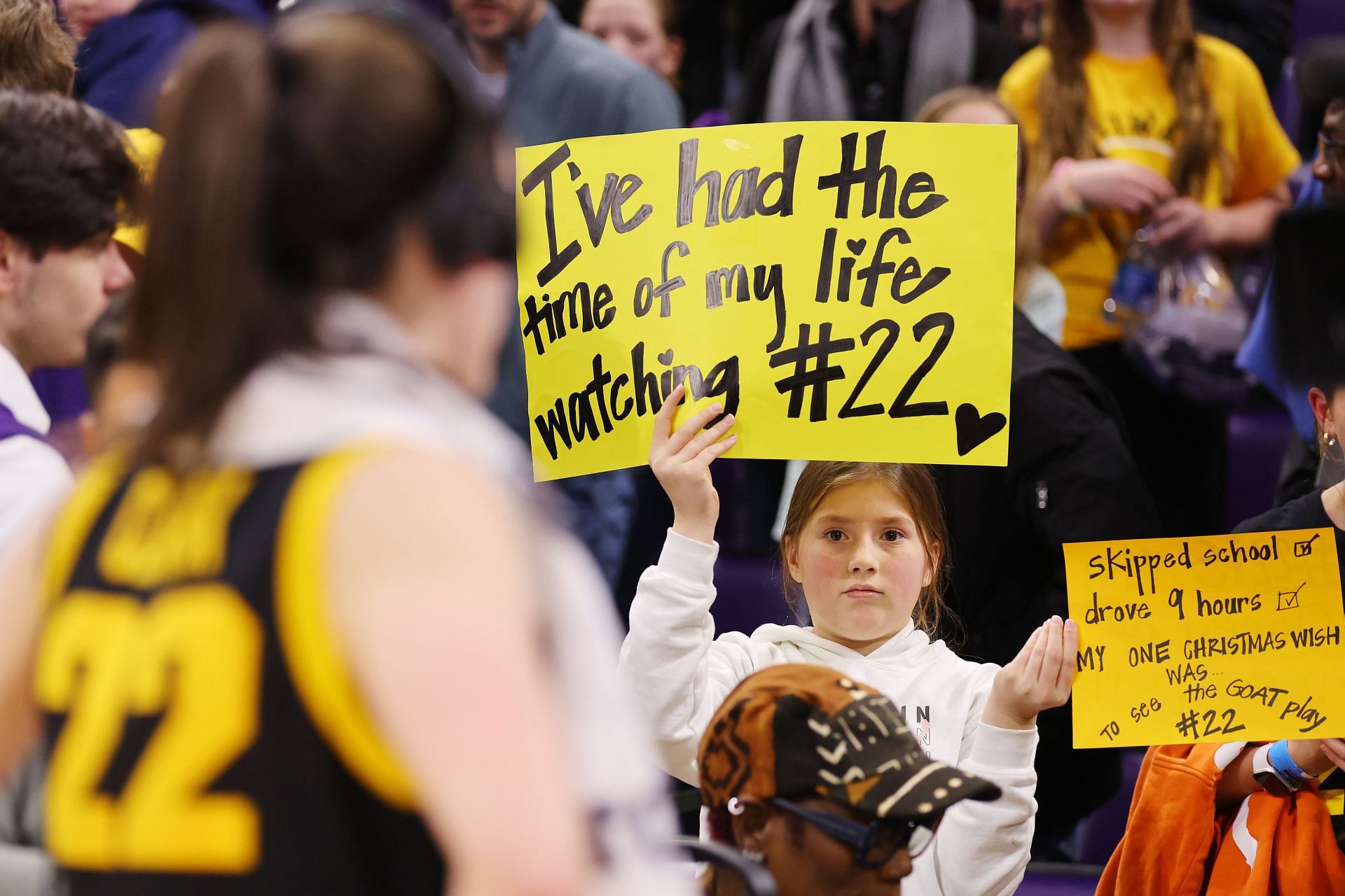 A young fan holds a sign for Caitlin Clark