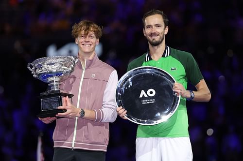 Jannik Sinner and Daniil Medvedev (R) with the 2024 Australian Open trophies.