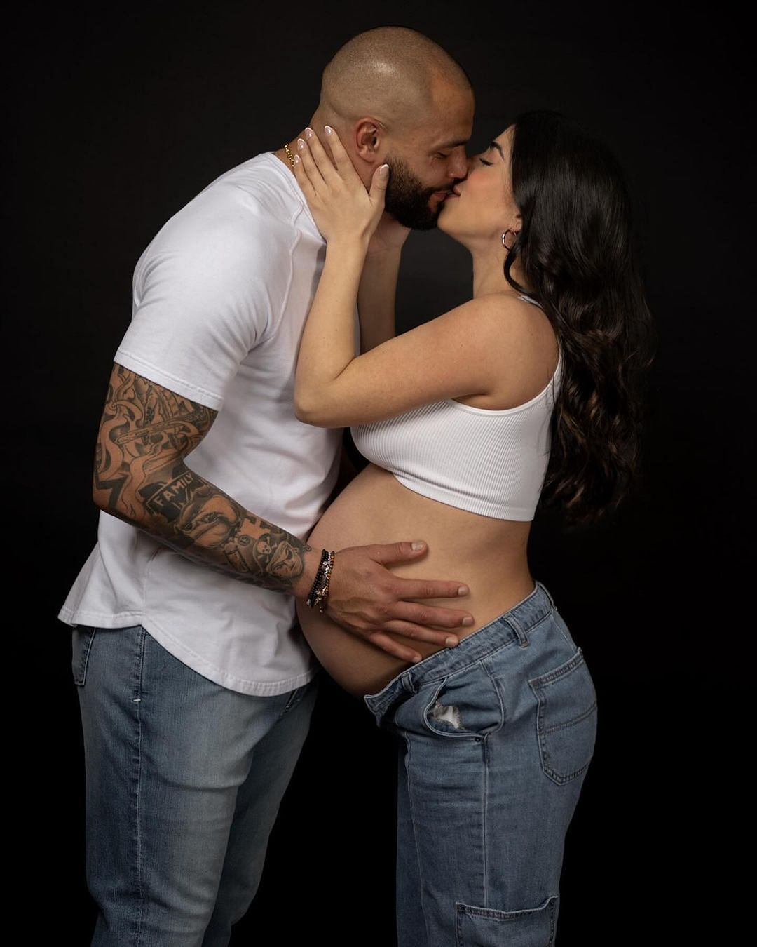 Prescott and Ramos share a kiss while holding her belly