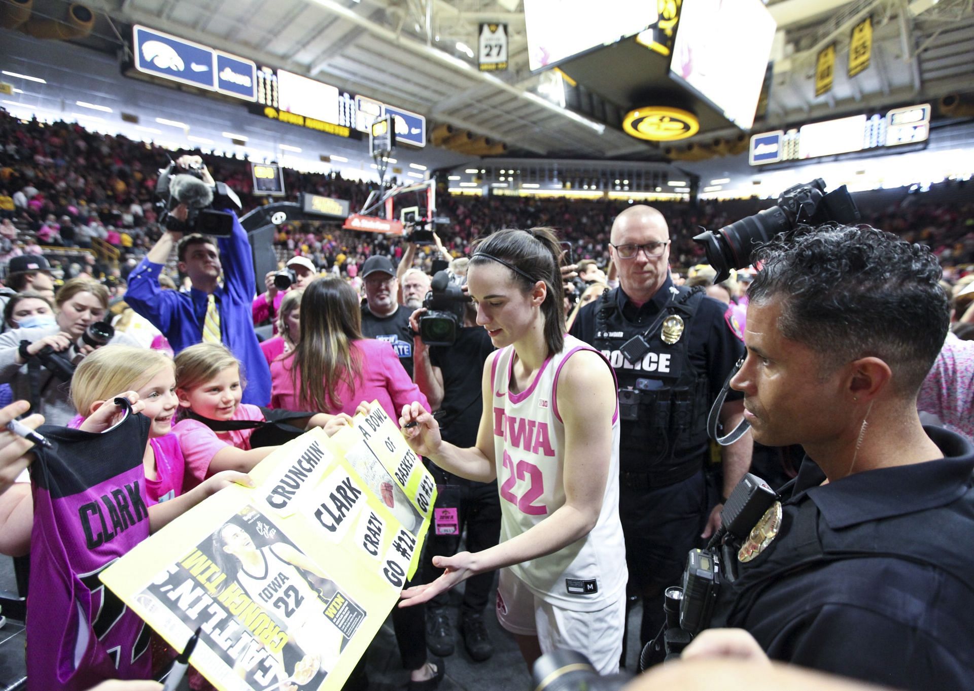 Caitlin Clark signs autographs as she leaves the court following the match-up against the Illinois Fighting Illini at Carver-Hawkeye Arena on February 25, 2024, in Iowa City, Iowa.