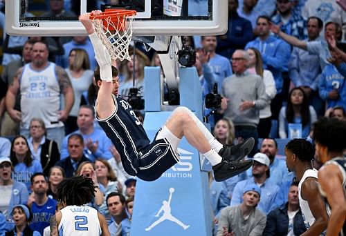 Kyle Filipowski #30 of the Duke Blue Devils hangs on the rim after a dunk against the North Carolina Tar Heels.