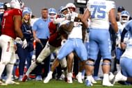 Payton Wilson #11 of the NC State Wolfpack tackles Omarion Hampton #28 of the North Carolina Tar Heels