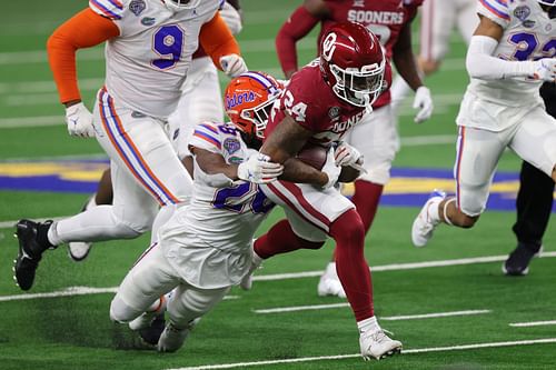 Running back Marcus Major #24 of the Oklahoma Sooners is tackled by linebacker Ty'Ron Hopper #28 of the Florida Gators