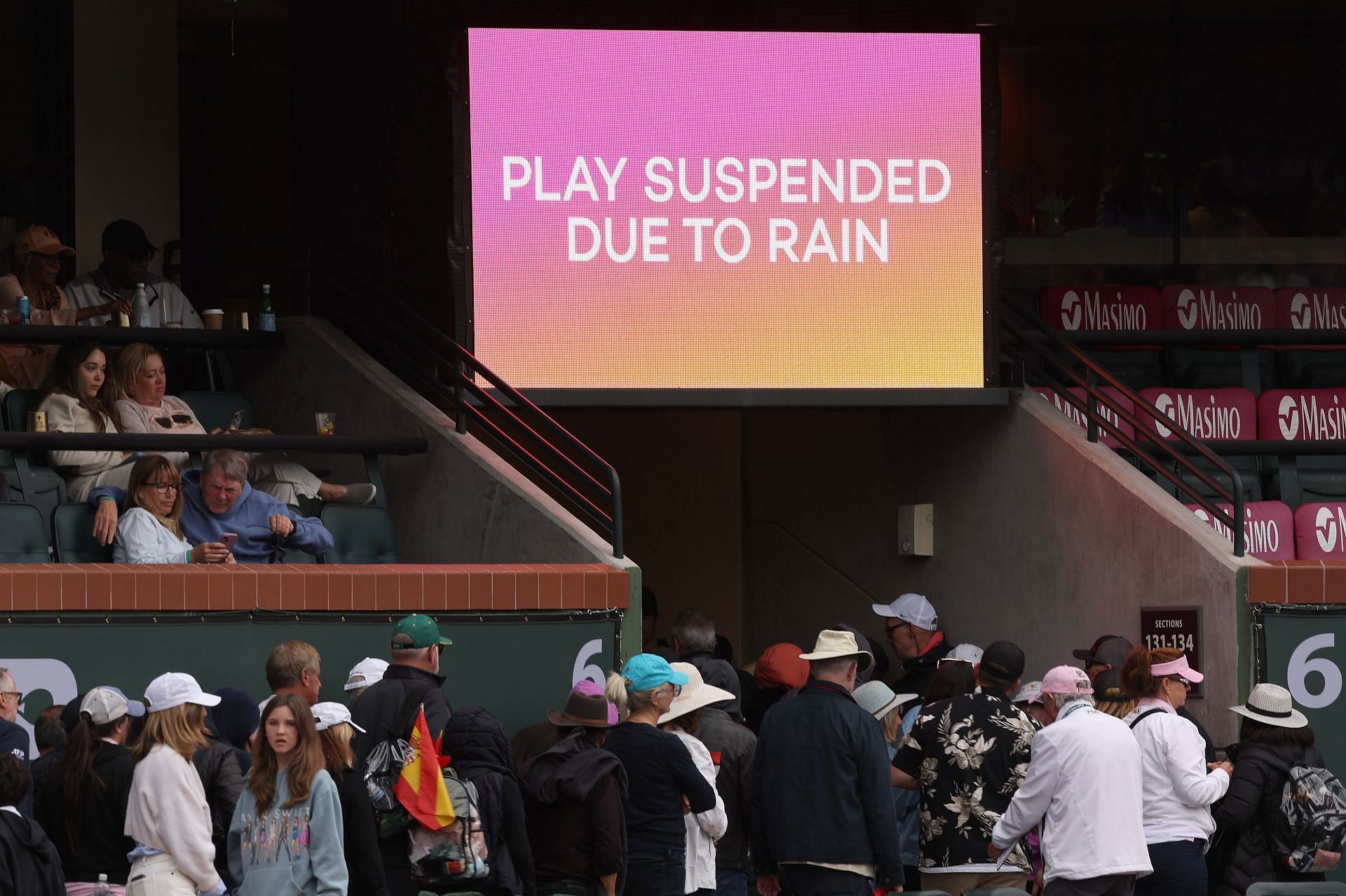 Spectators leave the stands during the rain-hit semifinal between Carlos Alcaraz and Jannik Sinner.