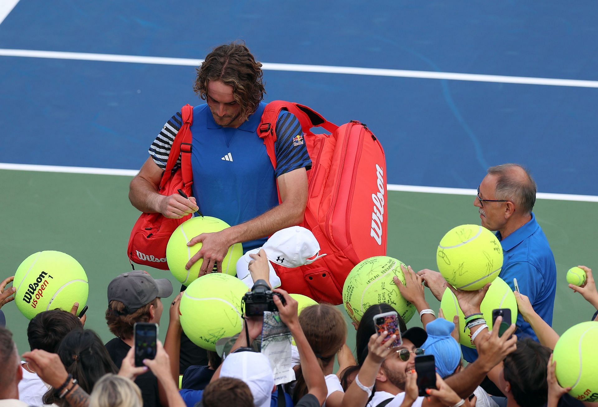 Stefanos Tsitsipas signs giant balls at the 2023 US Open