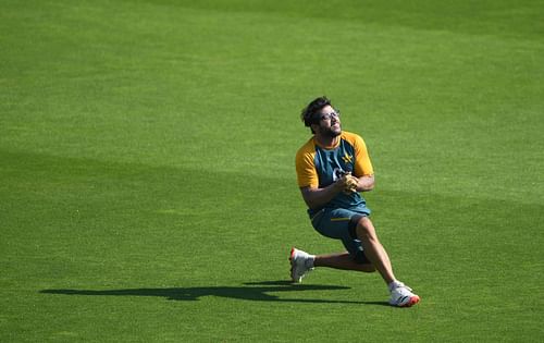 Imam attempts a sliding catch during warm-up.