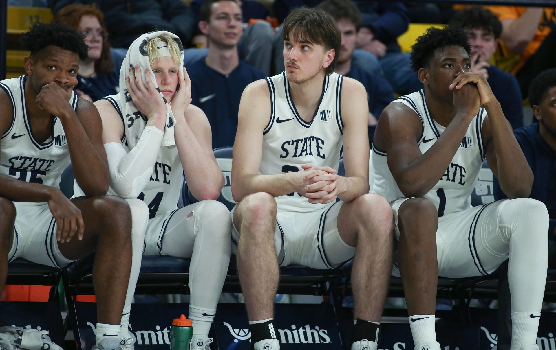 Nigel Burris #35, Karson Templin #24, Isaac Johnson #20 and Great Osobor #1 of the Utah State Aggies react on the bench during the final minutes against the Nevada Wolf Pack.