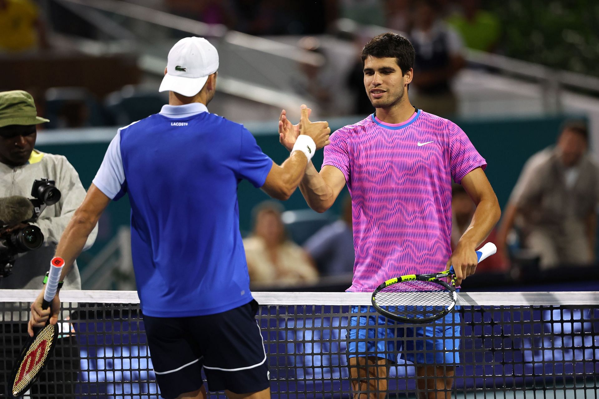 Grigor Dimitrov (L) and Carlos Alcaraz shake hands at the net after their Miami Open quarterfinal match