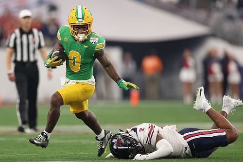 Running back Bucky Irving #0 of the Oregon Ducks rushes the football past safety Jaylon Jimmerson #2 of the Liberty Flames