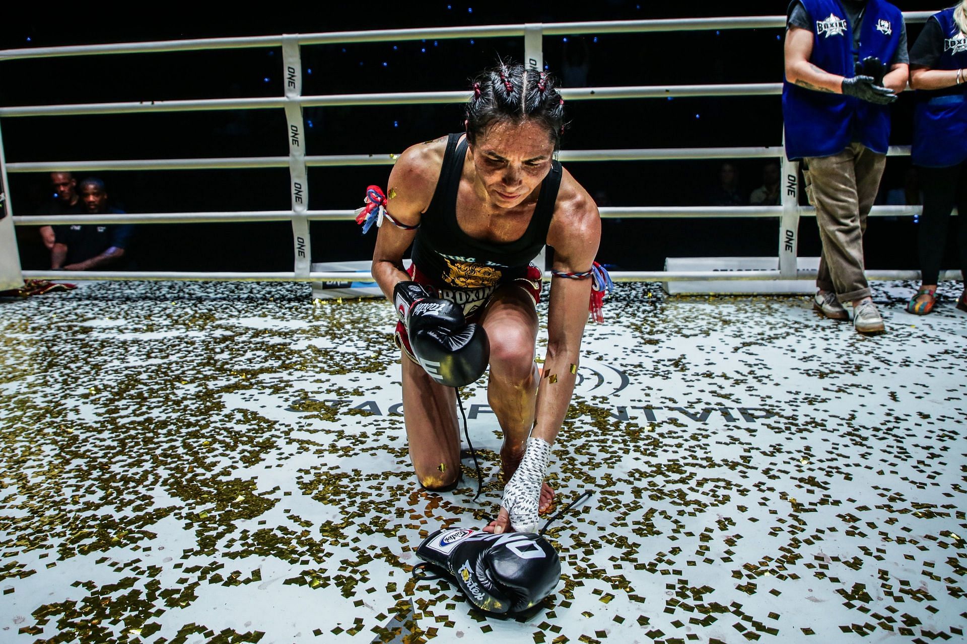 An emotional Janet Todd lays her gloves inside the Mecca of Muay Thai.