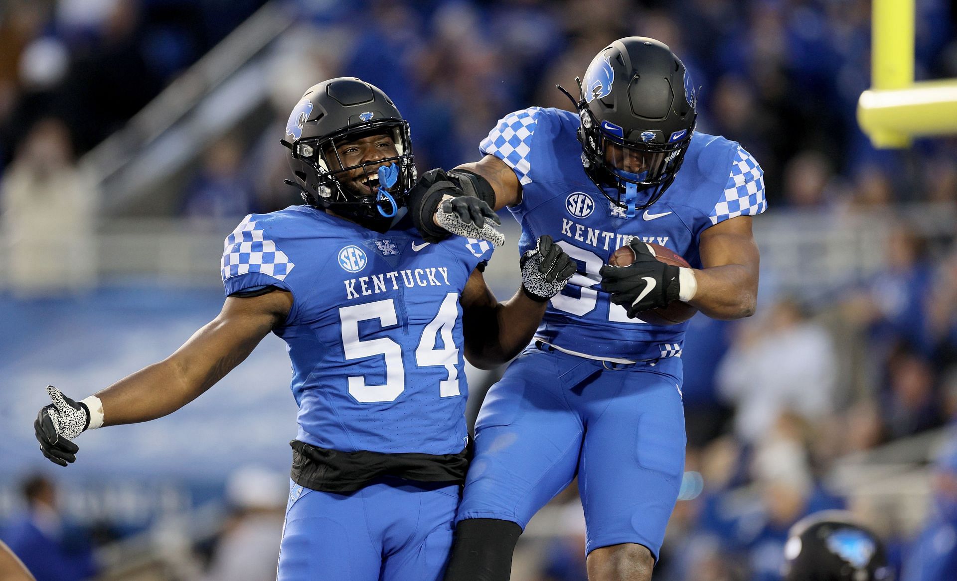 Trevin Wallace #32 of the Kentucky Wildcats celebrates with D'Eryk Jackson #54 after intercepting a pass against the Louisville Cardinals