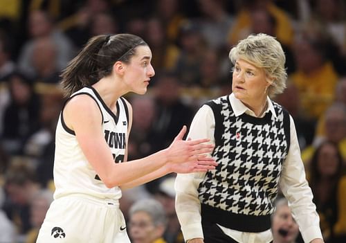 Caitlin Clark and Iowa head coach Lisa Bluder talking at the sidelines.