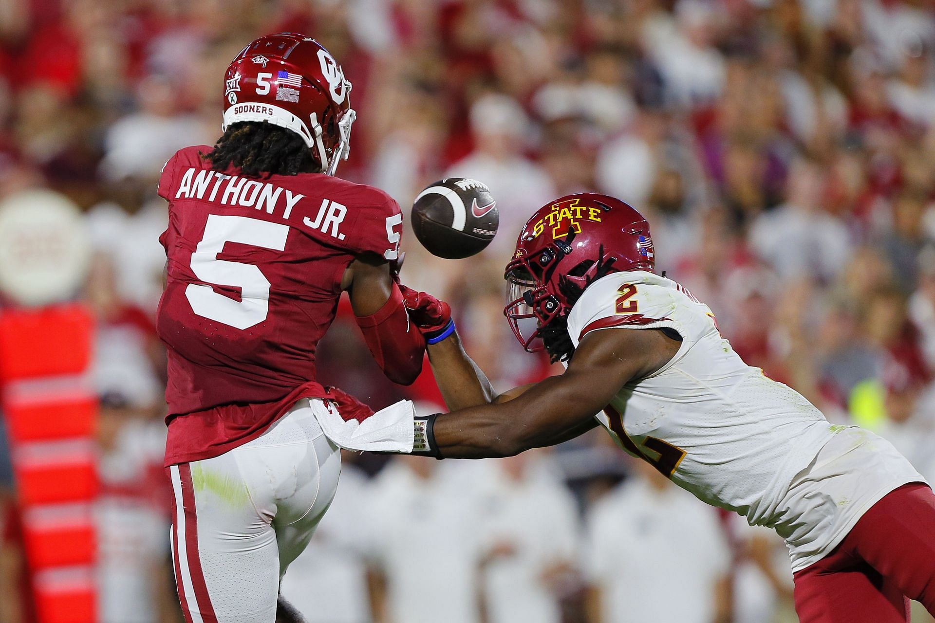 Andrel Anthony #5 of the Oklahoma Sooners loses control of a long pass as he is hit by defensive back T.J. Tampa #2 of the Iowa State Cyclones