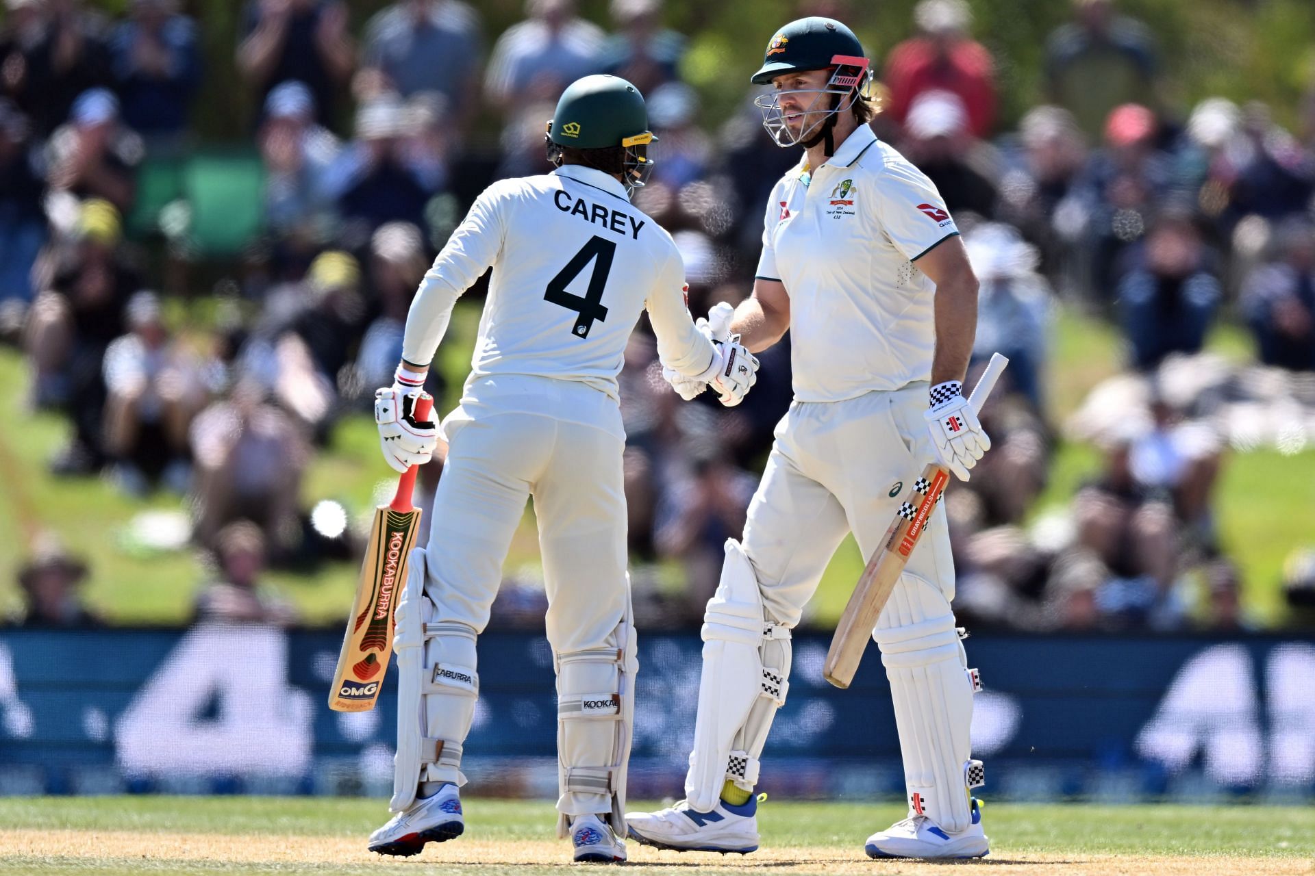 Mitchell Marsh of Australia (R) is congratulated by Alex Carey of Australia after scoring a half-century during day four of the Second Test in the series between New Zealand and Australia at Hagley Oval.