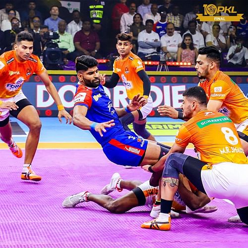 Star raider Vinay being pinned down by Puneri's defenders in the PKL final on Friday. [PKL Media]